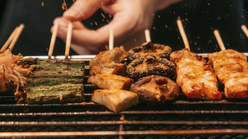 skewers being seasoned on a bbq