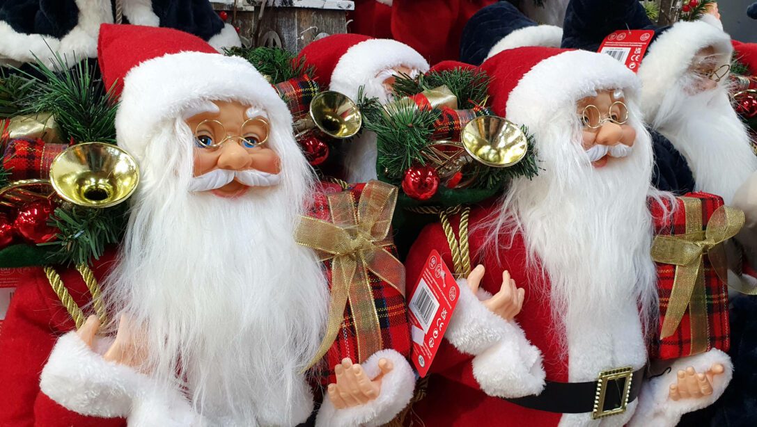 traditional christmas santa figures standing and holding a present